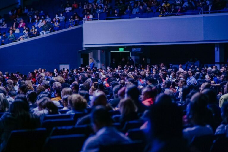 Sală de conferință cu scaune aliniate, pregătită pentru un eveniment cu public